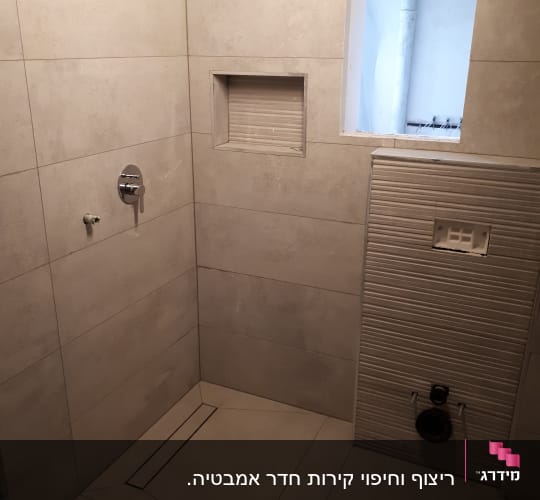 חדר אמבטיה בשיפוץ עם אריחים חדשים וקיר פתוח
